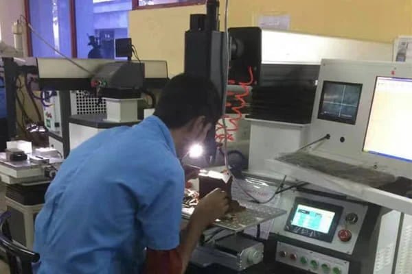 An engineer carefully setting parameters on the control screen of a laser welding machine